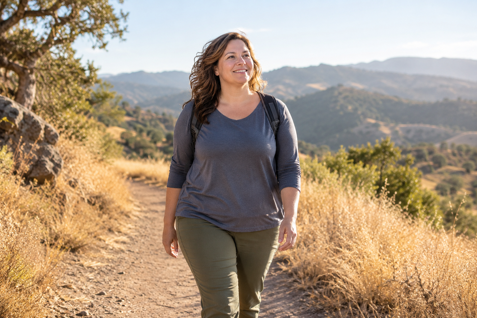 A woman enjoying a walk on a sunlit trail
